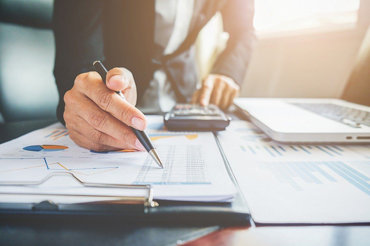 Managing business expenses during inflation on a notepad with a calculator from Preferred CFO