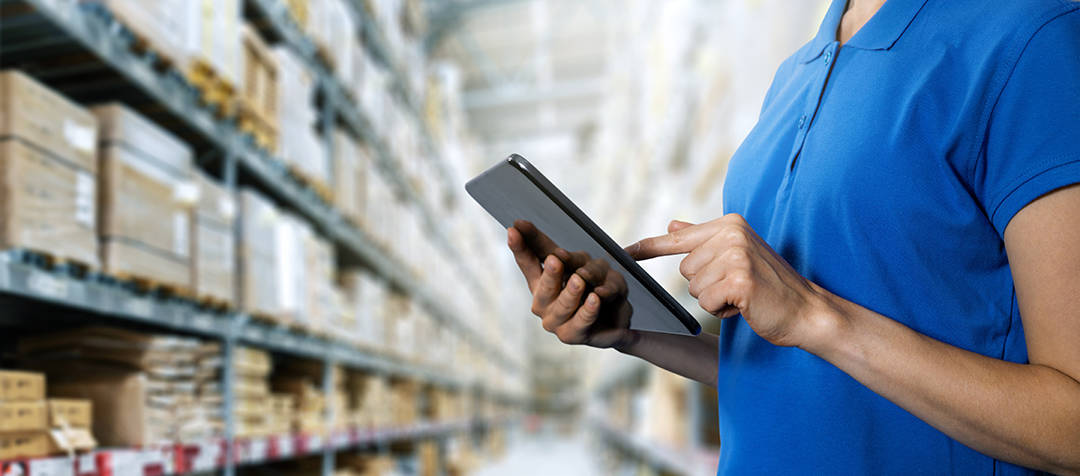 Woman in warehouse considering inventory strategy management techniques